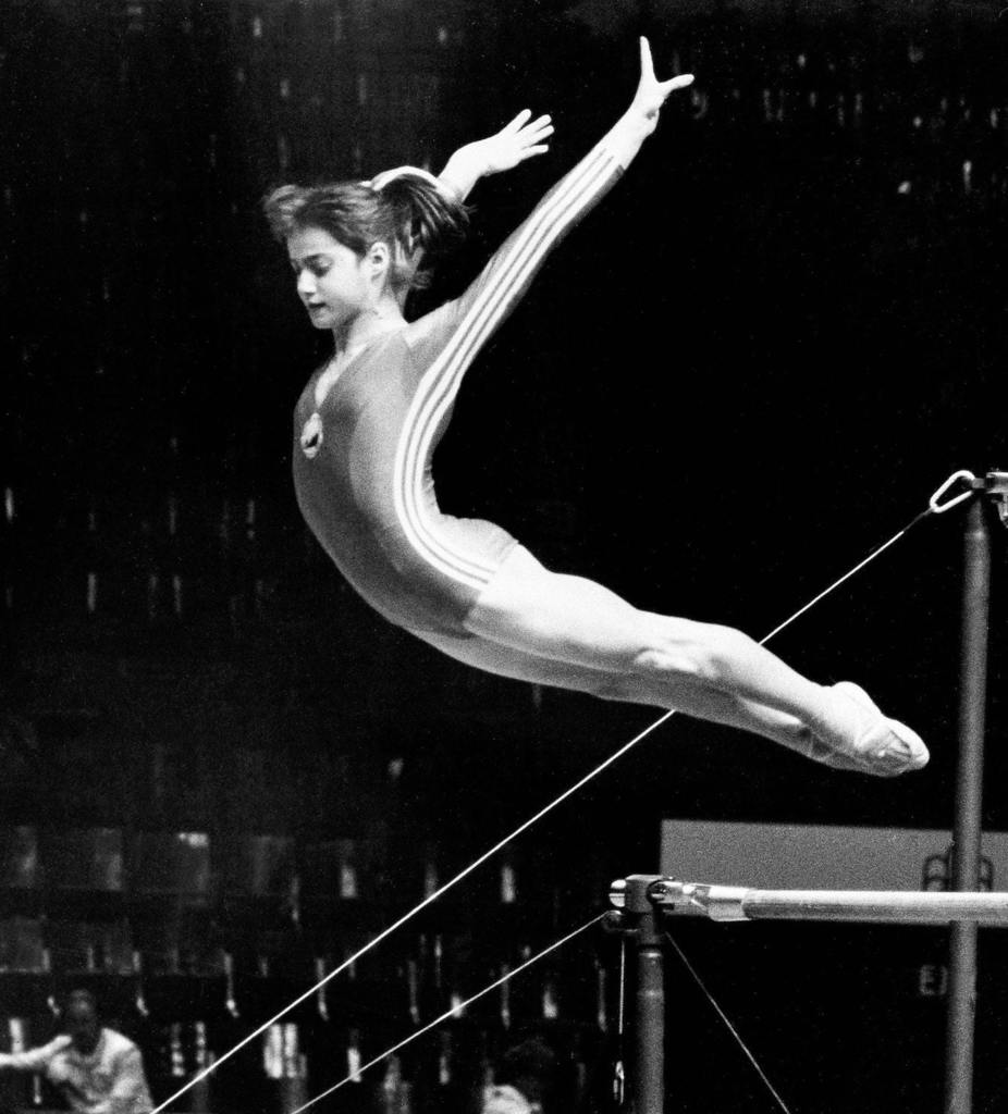 Romanian gymnast Nadia Comaneci performs a perfect jump-off from the uneven bars as she finishes her daily practice at the Montreal gymnasts' training site, July 13, 1976. The 14-year-old is expected to succeed Russian gymnast Olga Korbut as the darling of the 1976 Summer Games. (AP Photo)